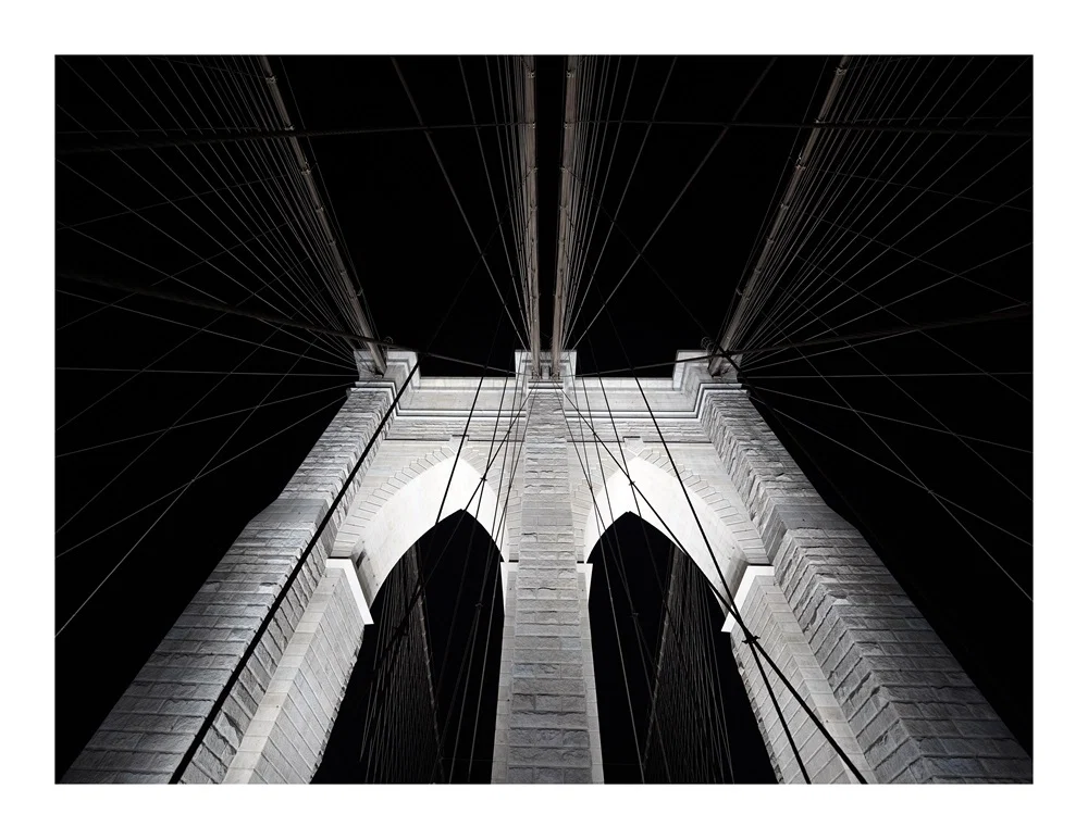 The top of one the arches on the Brooklyn bridge, by night