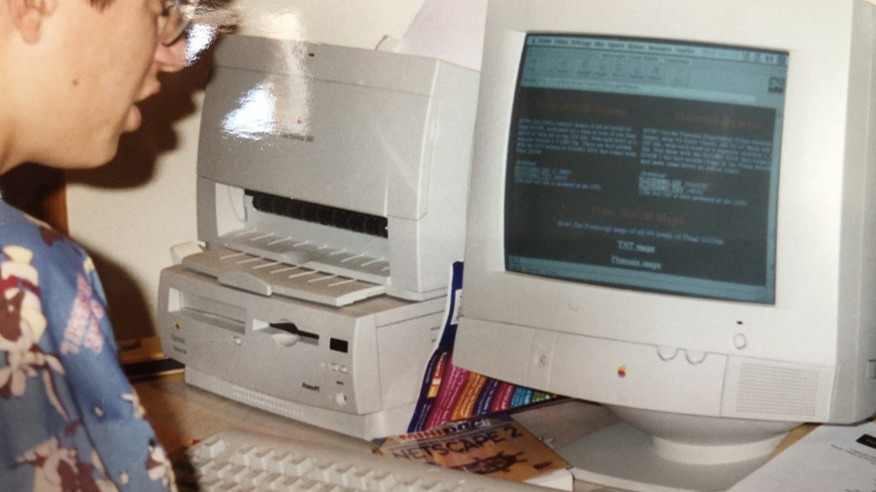 A photo of me, in front of an old Macintosh computer, surfing the web with Netscape Navigator 2, in 1996